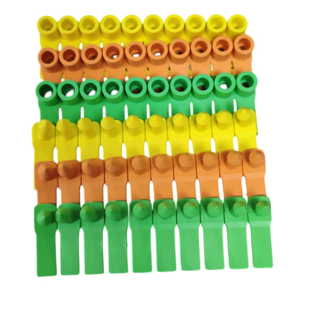 Yellowgreenorangeplasticfarmeartags,tagbodyandpinpartsarranged