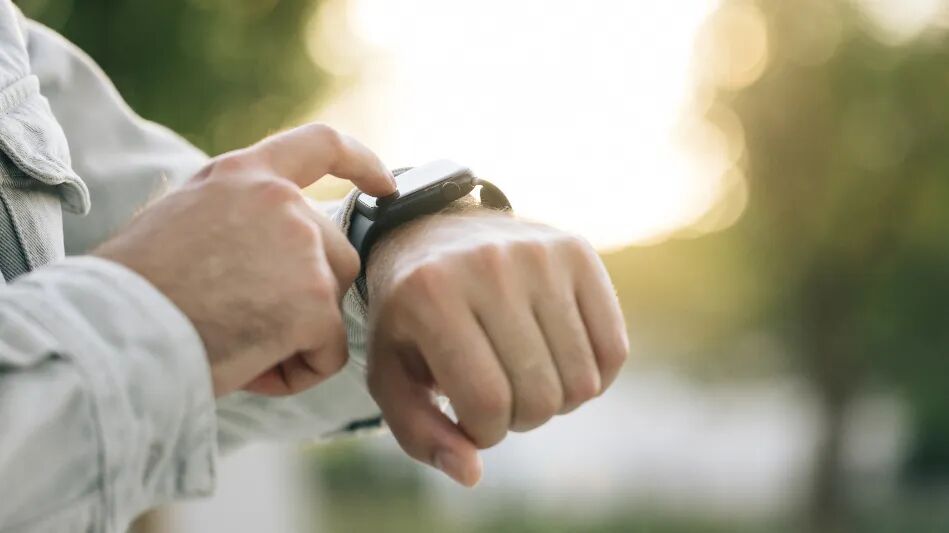 千库网_日落时分，男性在户外使用可穿戴智能手表的特写镜头。_摄影图编号16749298.jpg