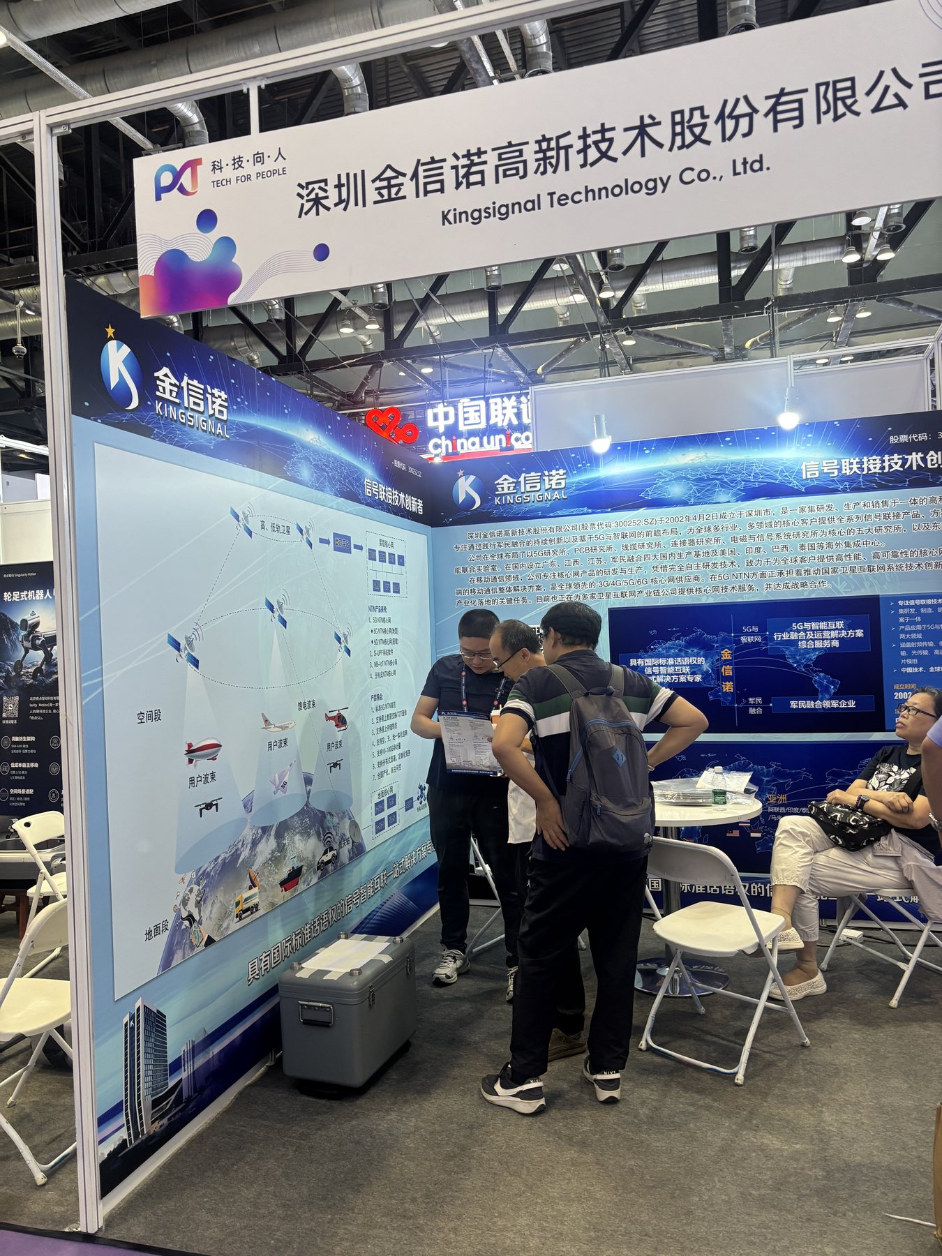 星地融合示意展板与企业介绍同框，观众正在阅读资料并交谈。